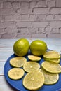 View of whole limes and slices of fresh lime Royalty Free Stock Photo