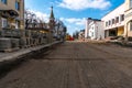 View of a wide city street where the sidewalk and asphalt are being repaired. Removal of old paving slabs for subsequent