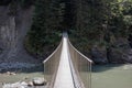 View of a wild river in a gorge with a modern hanging bridge