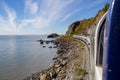 A view of the Wilderness rail service Train running along the ocean between the cruise