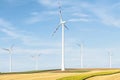 View of a wind power plant on a background of blue sky and fields with grain crops. The concept of environmental electricity produ Royalty Free Stock Photo