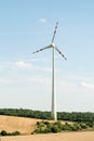 View of a wind power plant on a background of blue sky and fields with grain crops. The concept of environmental electricity produ Royalty Free Stock Photo