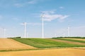 View of a wind power plant on a background of blue sky and fields with grain crops. The concept of environmental electricity produ Royalty Free Stock Photo