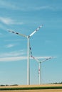 View of a wind power plant on a background of blue sky and fields with grain crops. The concept of environmental electricity produ Royalty Free Stock Photo