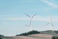 View of a wind power plant on a background of blue sky and fields with grain crops. The concept of environmental electricity produ Royalty Free Stock Photo