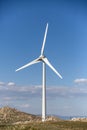 View of a wind turbine on top of mountains, blue sky as background Royalty Free Stock Photo