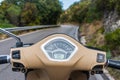 View of the winding road from behind the steering wheel of a scooter. Biker driving his motorcycle on country road in a village. Royalty Free Stock Photo