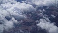 View from the window of an airplane on white fluffy clouds over the city on a clear sunny day, blue sky. Vacation travel by plane Royalty Free Stock Photo