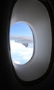 view from the window of an airplane wing in flight flying over white clouds Royalty Free Stock Photo