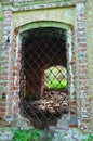 View of the window with black curly cast-iron grating on the wall of old fortress Royalty Free Stock Photo