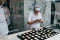 A view through the window of a cafe or glass as a chef prepares a traditional Portuguese dessert called Pastel de Nata.