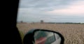 View from the window of a car moving along a field on which work is underway to collect waste. Royalty Free Stock Photo