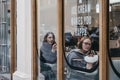 View through the window of customer enjoying the ice-cream inside the Milk Train shop in Covent Garden, London, UK