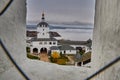 view from the window of the observation tower to the main entrance to the monastery through the white tower with a bell tower