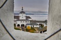 view from the window of the observation tower to the main entrance to the monastery through the white tower with a bell tower