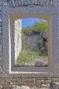 View through a window opening in an antique natural stone wall Royalty Free Stock Photo