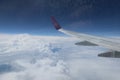The view through the window of the plane flying in the sky Saw the wings of the plane float above the white clouds Royalty Free Stock Photo