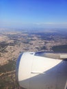 View from the window of the plane to the city of Lisbon and Portugal. Clear blue sky, aircraft engine and wing Royalty Free Stock Photo