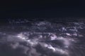 View from the window of the plane to the clouds at night and flashes of lightning.