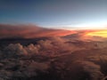 The view from the window of the plane to fantastically beautiful sunset above the clouds