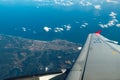 View from the window of the plane on the wing, the earth and the ocean Royalty Free Stock Photo