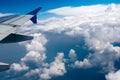 View from the window of the plane wing under the sunlight surrounded by clouds at daytime Royalty Free Stock Photo