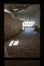 view through the window of a run down warehouse looking at a big pile of dirt