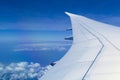 View from window seat of an airplane overlooking blue sky and clouds. Royalty Free Stock Photo