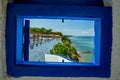 View from a Window at a Tavern at a Traditional Greek White Windmill on the Sea Shore on a Bright Sunny Day Royalty Free Stock Photo