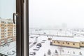 View from the window to the winter snow-covered parking lot in the courtyard of a multi-storey residential building Royalty Free Stock Photo