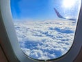 View of wing of an airplane flying above the clouds. Clouds and sky through an airplane window Royalty Free Stock Photo