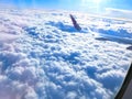 View of wing of an airplane flying above the clouds. Clouds and sky through an airplane window Royalty Free Stock Photo