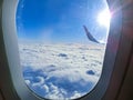 View of wing of an airplane flying above the clouds. Clouds and sky through an airplane window Royalty Free Stock Photo