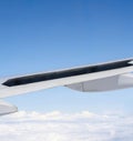 View of wing of airplane with open flaps from window with blue sky above clouds background Royalty Free Stock Photo