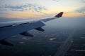 View of the wing of the plane and the city and the road in the morning at dawn. Royalty Free Stock Photo
