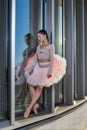 Dance Sport Ideas. Winsome Sexy Slim Professional Caucasian Ballet Dancer in Pink Tutu Dress Standing Against Metal Glass Royalty Free Stock Photo