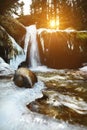 View from Winter landscape. Not a large waterfall of a mountain river with frozen banks in the light of the setting sun Royalty Free Stock Photo