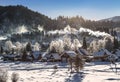 View of the winter the village Iogach against the background of forested mountains. Altai Republic