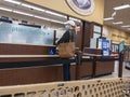 Kirkland, WA USA - circa October 2021: View of a woman in a baseball hat picking up a prescription at a pharmacy inside a Safeway Royalty Free Stock Photo