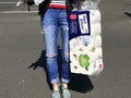 View on woman carrying one final bag of rationed toilet paper and toiletries