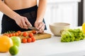 View of woman cutting red cherry tomatoes on cutting board Royalty Free Stock Photo