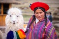 View of woman in national clothing and white shaggy lama in Sacsayhuaman