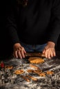 View of woman's hands with rolling pin on gingerbread cookie dough on table with molds and flour, Royalty Free Stock Photo