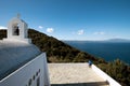 View of woman standing on the edge of the small chapel of Saint Alexander in Skiathos island, Greece