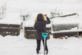 View of a woman taking pictures of her snowy backyard on her mobile.