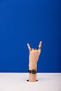 View of woman with wristwatch on hand showing rock sign  on blue Royalty Free Stock Photo