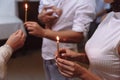 View of women and a man, holding in hands candles and a baby during the Epiphany in russian orthodox church