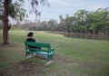 View of the women sitting on the green bench and relax in the park in the evening
