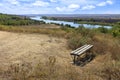 View of a wooden bench on a high river bank on a bright autumn day. Rural autumn landscape Royalty Free Stock Photo