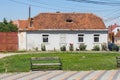 A view of a wooden bench and a water tower next to a historic house in the town of Greenbow. Transylvania. Romania Royalty Free Stock Photo